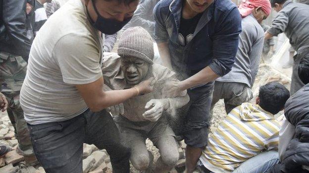 People try to free a man from the rubble of a destroyed building after an earthquake hit Nepal, in Kathmandu, Nepal, on 25 April 2015