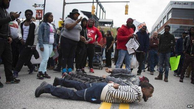 Demonstrators lie on the street to block traffic as others march protesting the death of Freddie Gray, an African American man who died of spinal cord injuries in police custody, in Baltimore, Maryland, on 25 April 2015