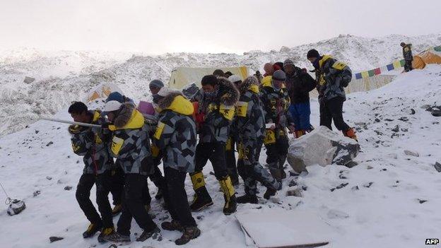 Rescuers carry injured person to helicopter - 26 April