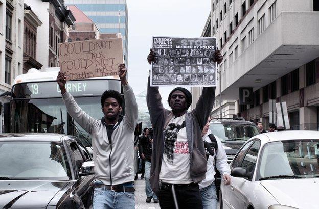 Two men with signs in traffic.