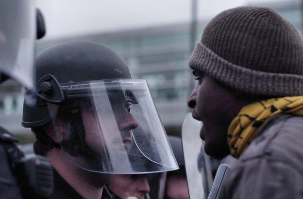 Protestor in the face of a police officer.