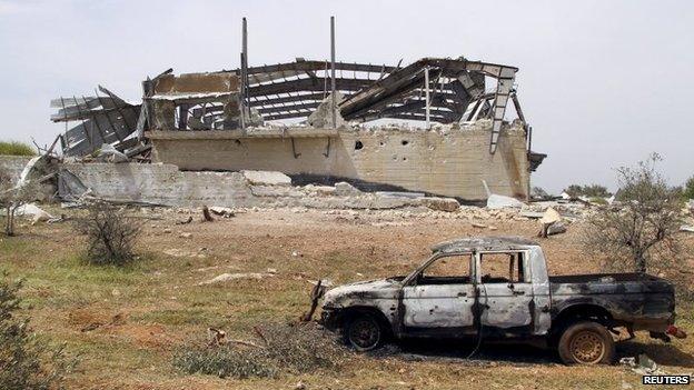 Wrecked building and vehicle at al-Qarmid military base in Idlib province (27 April 2015)