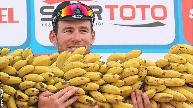 Mark Cavendish is presented with a large bunch of bananas