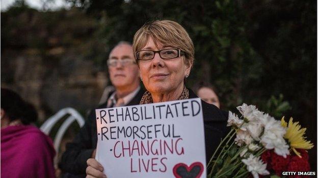 An Australian woman holds up a sign supporting the Bali 9 men on Indonesia's death row