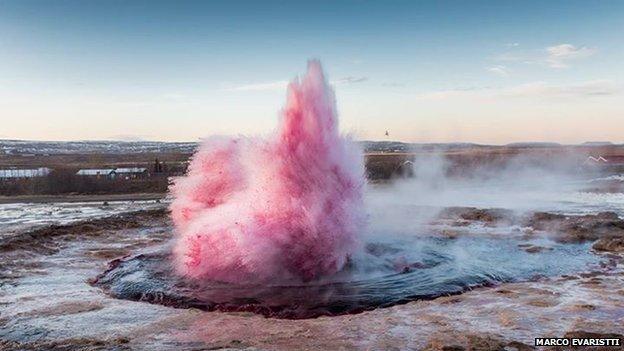 The geyser spurting pink water.