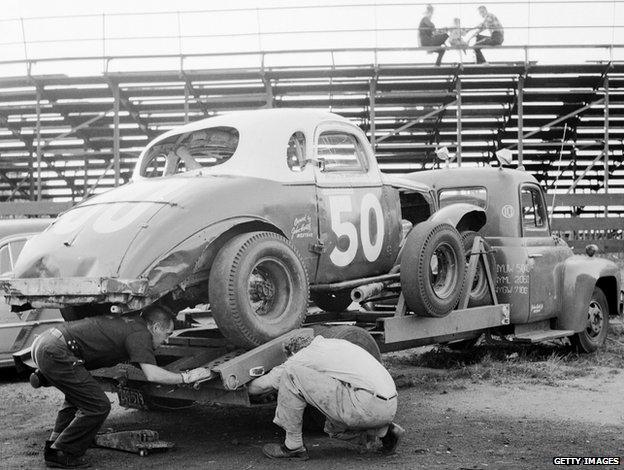 Stock car being unloaded from its trailer