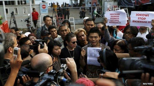 An Indonesian activist (C) holds a document as he talks to reporters during a protest against the execution of Brazilian death row prisoner Rodrigo Gularte in front of Wijayapura port in Cilacap