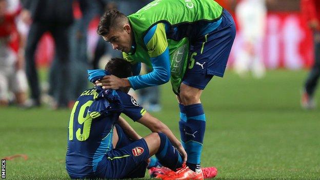 Santi Cazorla (left) consoled by centre-back Gabriel Paulista