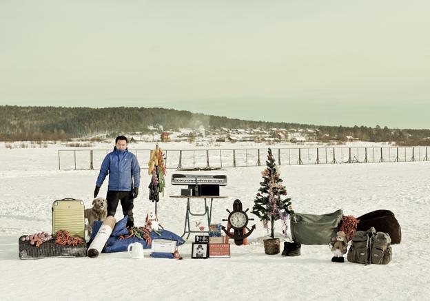 Wang Jafeng standing in the snow with his possessions