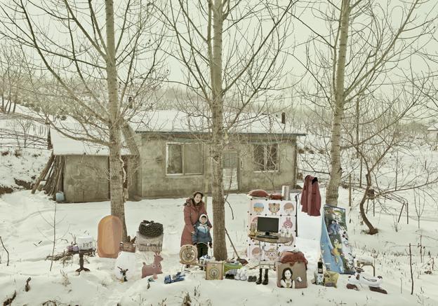 Liu Chunxiao and her son standing in the snow with their possessions