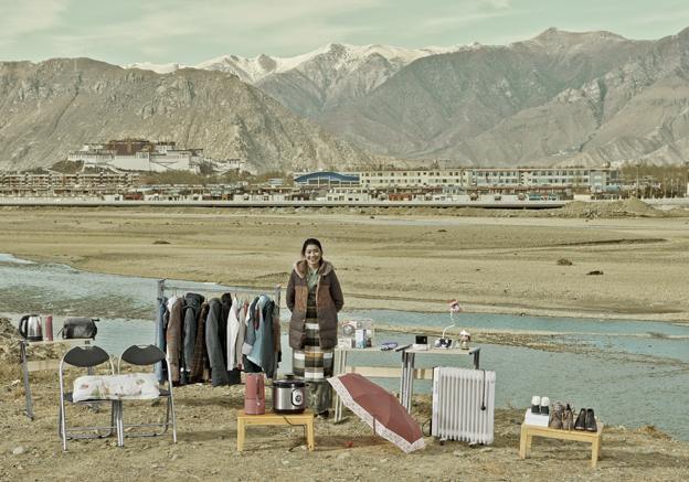 Yang Chin standing outside with clothes and an umbrella