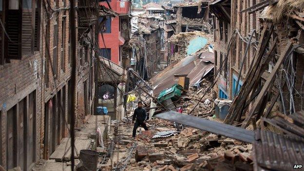 Man walks through rubble of houses damaged by the earthquake in Bhaktapur near Kathmandu on 28 April 2015.