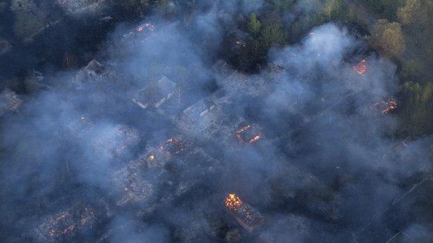 Fire hits an abandoned village in the exclusion zone around Chernobyl, Ukraine, Tuesday, April 28, 2015,