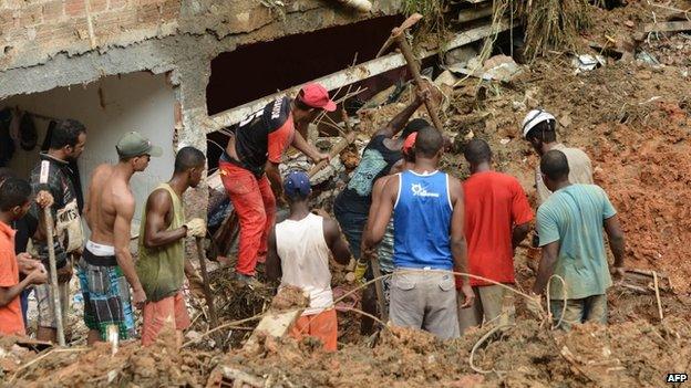 Residents and rescuers search for victims after a landslide in Salvador, Bahia, Brazil, on 28 April, 2015.