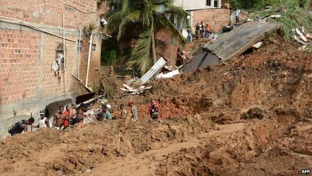 Residents and rescuers search for victims after a landslide in Salvador, Bahia, Brazil, on 28 April, 2015.