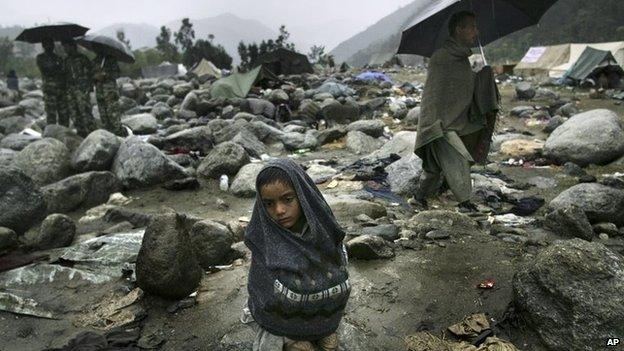 A Pakistani earthquake survivor shivers in the rain at a refugee camp in Balakot, Pakistan Saturday, Oct. 15, 2005