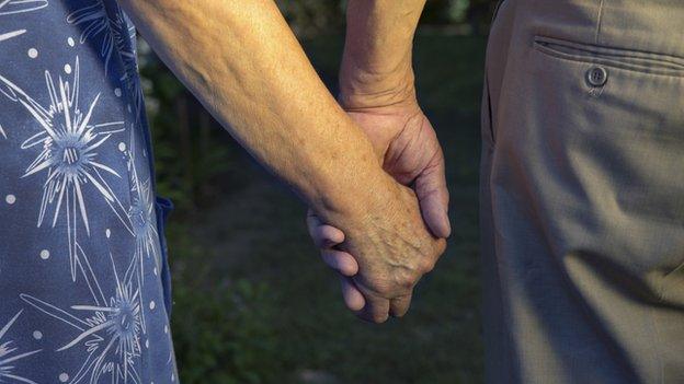 Older people holding hands