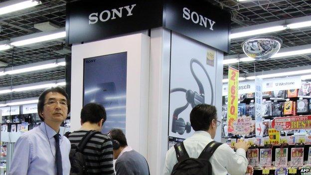 Customers check Japanese electronics giant Sony's headphones at an electronics shop in Tokyo on 30 April 2015