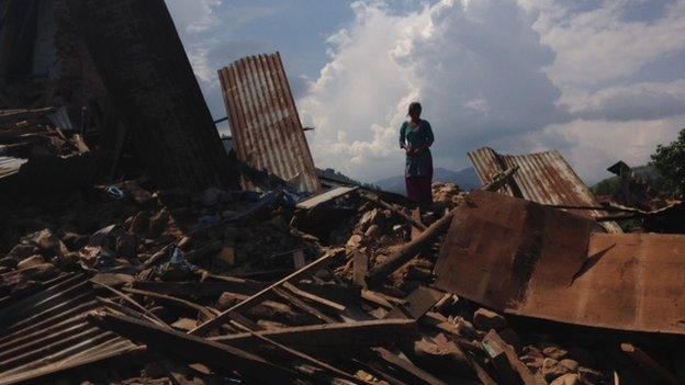 A woman stands on the rubble in the village of Deupur Sipaghat Kavre after the earthquake in Nepal, 30 April 2015.