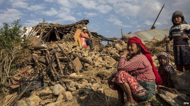 People in front of ruined home in Kathmandu, Nepal (27 April 2015)