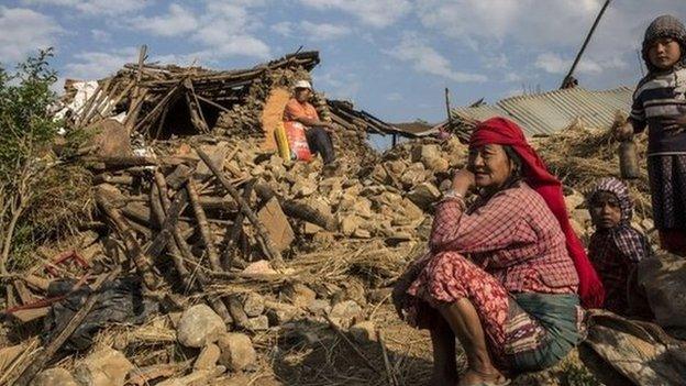 People in front of ruined home in Kathmandu, Nepal (27 April 2015)