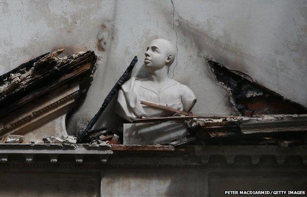 A bust sits on top a a fire damaged door entrance in The Marble Hall at Clandon Park House