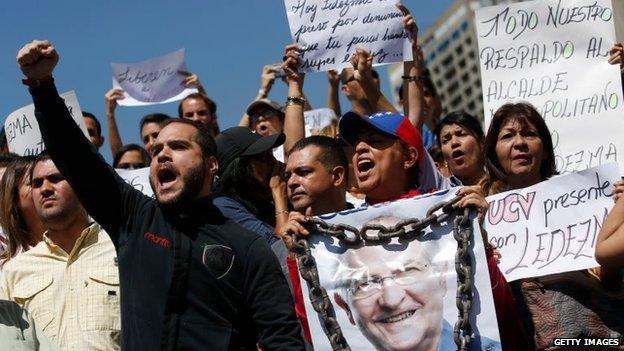 A supporter of Caracas Mayor Antonio Ledezma holds a poster of him with chains during a protest demanding his release in Caracas on 20 February, 2015.