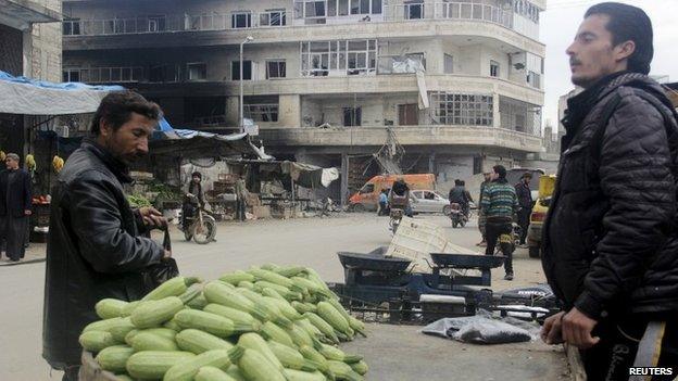 A man buys courgette from a stall in Idlib, Syria (1 April 2015)