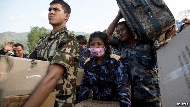 Nepali relief personnel carrying relief material wait to board an Indian Air Force helicopter in Dhading, Nepal on 30 April, 2015