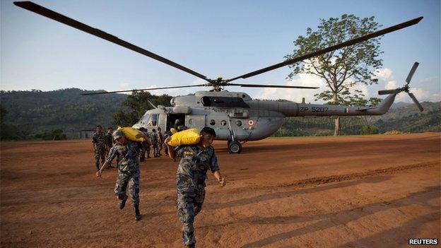 Nepali relief personnel carrying relief material wait to board an Indian Air Force helicopter in Dhading, Nepal on 30 April, 2015