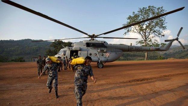 Nepali relief personnel carrying relief material wait to board an Indian Air Force helicopter in Dhading, Nepal on 30 April, 2015