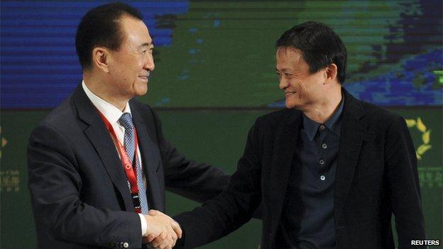 Wang Jianlin shakes hands with Jack Ma, executive chairman of Alibaba Group, at a conference in Shenyang, Liaoning province on 21 April, 2015