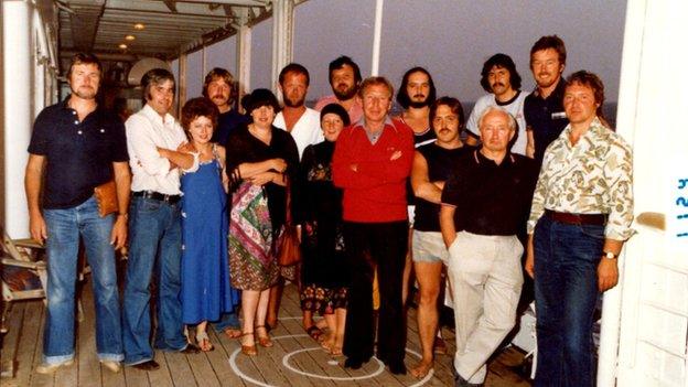 Iestyn Garlic ( y dyn gyda barf a mwstash sy'n eistedd yn y cefn ar y dde) Gyda cynhyrchydd Miri Mawr Peter Elias Jones wrth ei ochr ar y dde. Pellach i'r chwith ar y cefn mae John Pierce Jones barfog hefyd. Ydych chi'n nabod rhai o'r wynebau eraill?