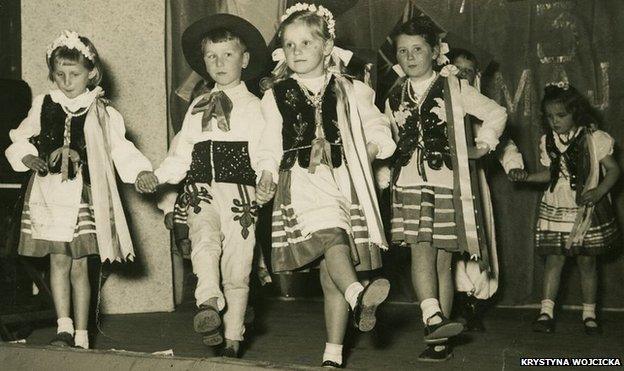 Krystyna Wojcicka and other children dance in traditional Polish costumes