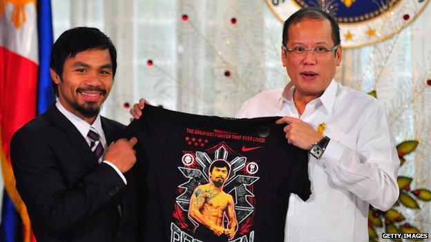 Boxer and congressman, Manny Pacquiao gives President Benigno Aquino III a shirt and memorabilia following his win of the WBC super welterweight crown against Mexican Antonio Margarito on November 20, 2010 in Manila, Philippines.