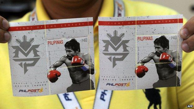 A post office employee shows commemorative stamps of Philippine boxing icon Manny Pacquiao in Manila on April 21, 2015