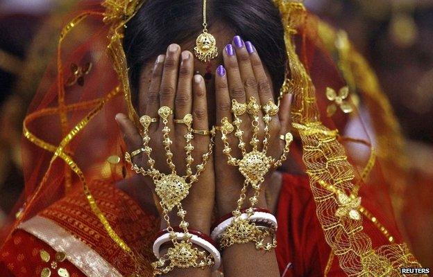 A bride covers her face as she waits to take her wedding vow at a mass marriage ceremony at Bahirkhand village, north of Kolkata February 8, 2015.