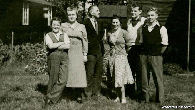 Wojciech Kurowski with family outside a hut