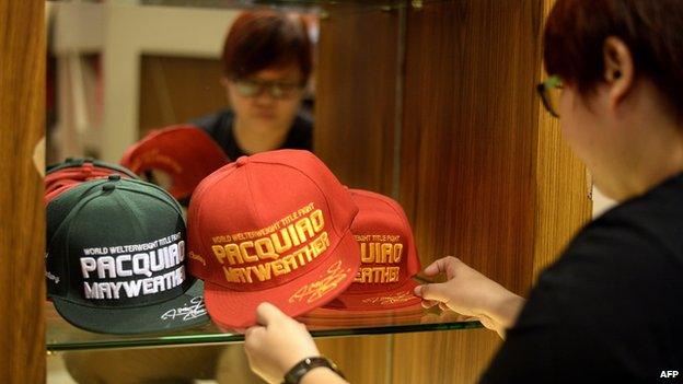 A store keeper arranges hats ahead of the boxing bout between Manny Pacquiao and Floyd Mayweather, at a store in Manila.