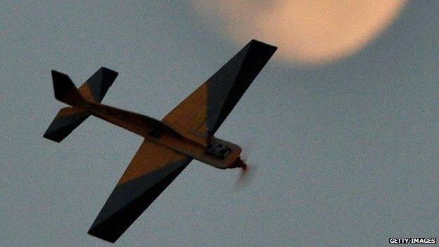 A model aircraft flies in front of the moon