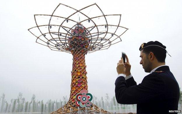 A policeman takes pictures at the "Tree of life" at Expo 2015 in Milan, Italy, 1 May 2015