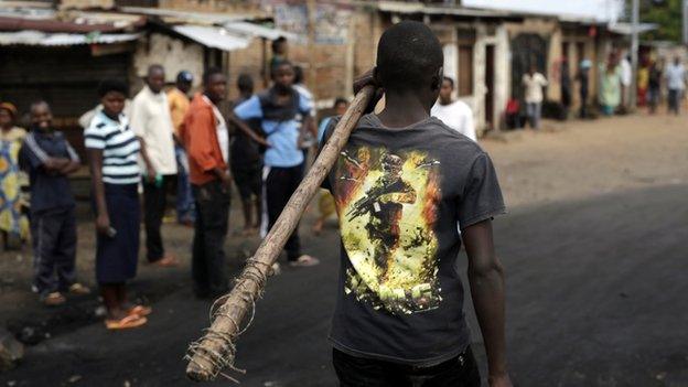 A demonstrator carrying a stick walks in Bujumbura, on 1 May 2015