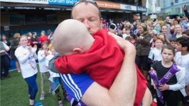 James Rudolf hugs his son Oscar after finishing the run