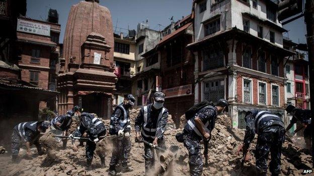 Members of the Nepalese police clear debris from the historical Durbar square in Kathmandu