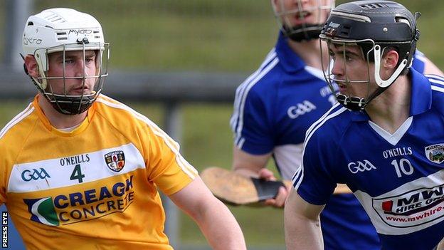 Antrim's Arron Graffin closes in on Michale Dudley of Laois