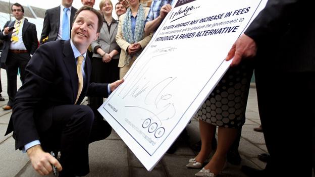Nick Clegg sings a large cardboard pledge to vote against any increase in tuition fees before the Lib Dem Scottish Party Conference in 2010
