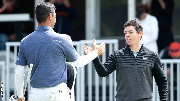 Gary Woodland and Rory McIlroy shake hands