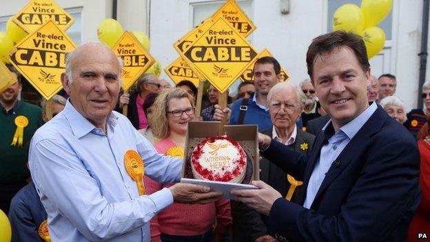 Nick Clegg and Vince Cable hold a cake after the Lib Dem leader's visit to Mr Cable's Twickenham constituency