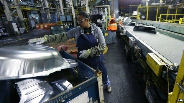 A factory worker assembling a car