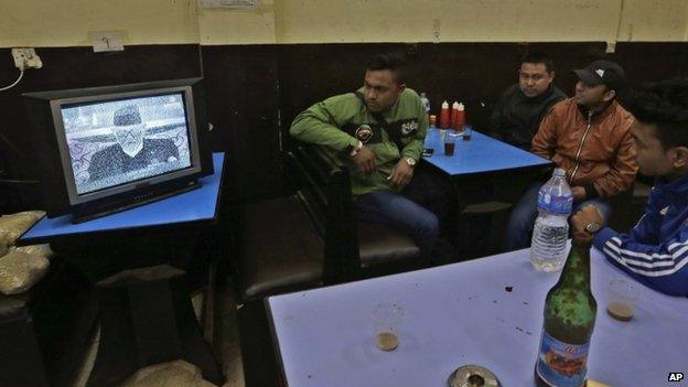 Nepalese people at a restaurant watch on a Black and White television their Prime Minister Sushil Koirala address the nation in Kathmandu, Nepal, Tuesday, April 28, 2015